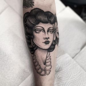Elegant forearm tattoo by Lamat blending flower, woman, and intricate dotwork and fine line details. A timeless piece of art.