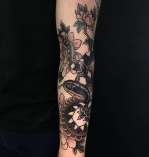 Intricate snake and flower design in bold blackwork style, expertly done by artist Kiko Lopes. A striking addition to your sleeve!