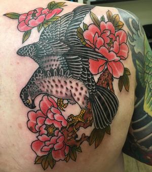 Stunning shoulder tattoo by Kiko Lopes featuring a majestic eagle and delicate flower in traditional Japanese style.