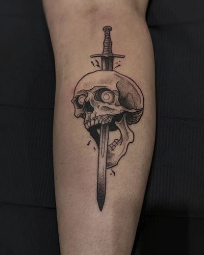 Intricate black and gray design by tattoo artist Luca Salzano, featuring a menacing skull and sharp dagger motif.
