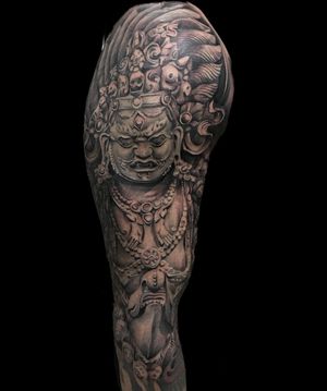 Impressive black and gray illustrative tattoo featuring a crown, man, and mask, expertly done by artist Avi.