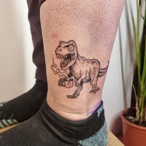 Vibrant lower leg tattoo of a playful dino holding a cup, expertly done by Jonathan Glick. A fun and colorful addition to your ink collection.