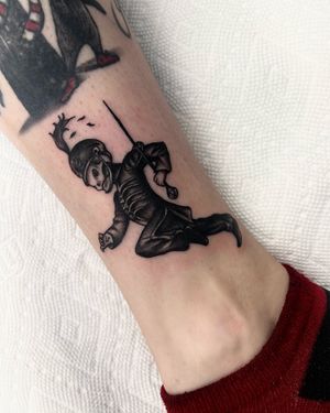 Get an edgy blackwork tattoo on your ankle featuring a skull, sword, and cap design by Miss Vampira.