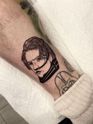 Get a bold and detailed illustrative blackwork tattoo of a man on your lower leg by artist Miss Vampira.