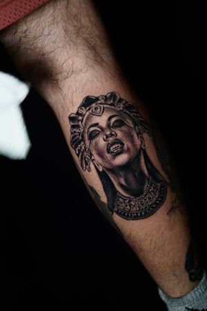 Embrace your inner vampire with this blackwork and realistic lower leg tattoo of a woman crowned as royalty by Miss Vampira.