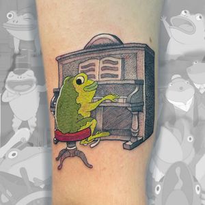 Vibrant forearm tattoo featuring a whimsical frog playing a piano, created by artist Galen Bryce (Drip Skull).