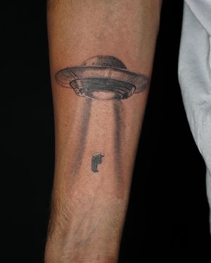 Explore the unknown with this fine line black and gray spaceship abduction tattoo by Soheyl Astangi.