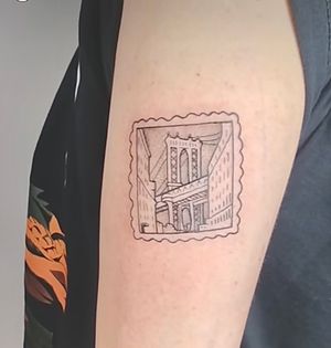 Finely detailed tattoo on upper arm featuring a bridge, card, and city skyline in an ignorant style by Jonathan Glick.