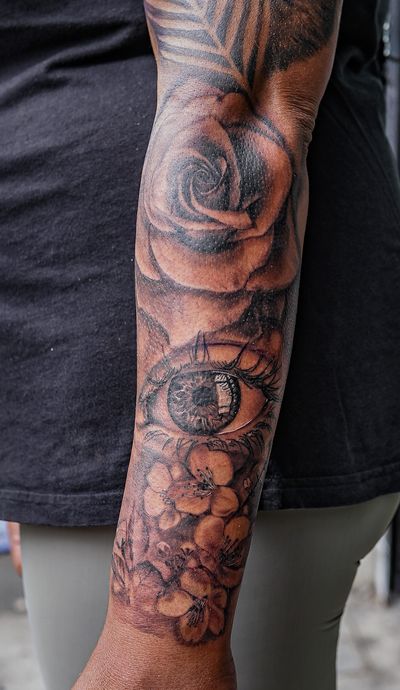 Get a stunning half sleeve tattoo featuring a beautiful rose and mesmerizing eye, created by the talented Soheyl Astangi.