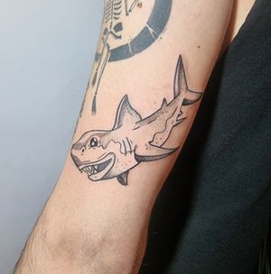 Don't fear the water with this vibrant new school shark design on your upper arm. Dive into the deep with confidence!