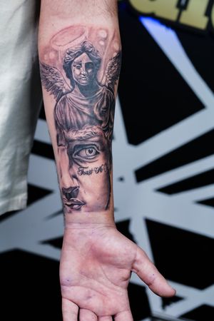 Elegant black & gray micro-realism forearm tattoo by Soheyl Astangi captures a mythical angelic statue in surreal detail.