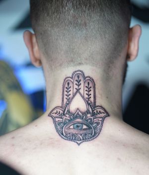 Beautifully detailed upper back tattoo by Soheyl Astangi featuring a heart, hamsa, and hand motifs.