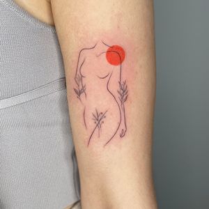 Fineline tattoo of a female silhouette with floral and colour accents 