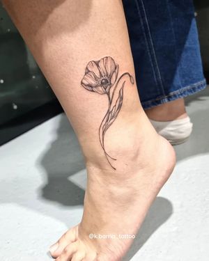 Elegant and delicate ankle tattoo of a flower done in fine line style by Katia Barria