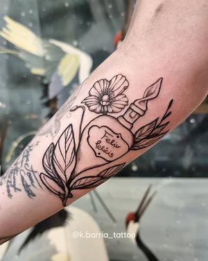 Ignorant style forearm tattoo by Katia Barria featuring a delicate design of a bottle, flowers, and a meaningful quote in black and gray.