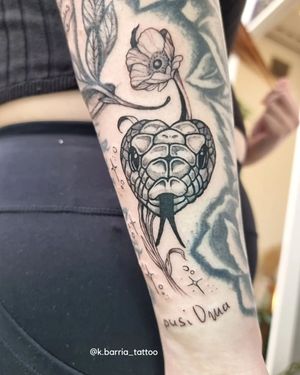 Elegant black and gray forearm tattoo featuring a snake and flower, expertly done by Katia Barria for a timeless and sophisticated look.
