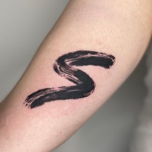 Abstract brushstroke tattoo in black 