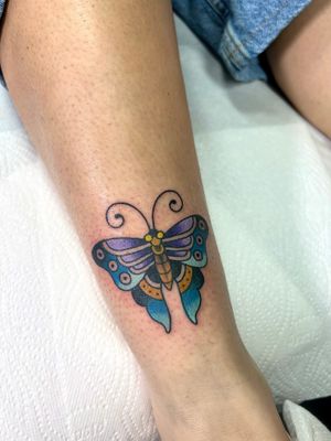 Experience the whimsical beauty of a butterfly tattoo on your shin, expertly done by tattoo artist Adam Ruff.