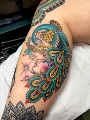 Exquisite upper arm tattoo by Adam Ruff featuring a stunning peacock and a beautiful woman in neo traditional style.