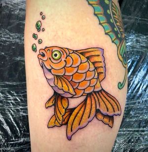 Get inked by renowned artist Adam Ruff with a vibrant traditional fish motif on your lower leg. Timeless and bold!