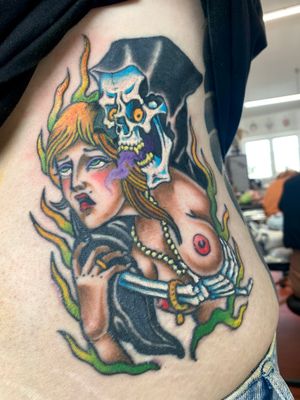 Vibrant new school style rib tattoo of a woman symbolizing death, expertly done by artist Adam Ruff.