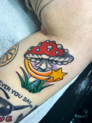 Vibrant new school design by Adam Ruff on upper arm featuring stars and mushrooms.