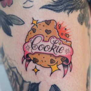 Neo-traditional arm tattoo featuring a cookie motif and inspiring quote by Adam Ruff. Perfect blend of small lettering and intricate design.