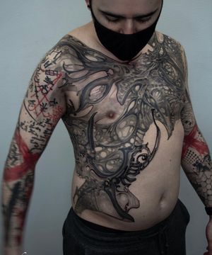 Get mesmerized by Gifford Kasen's detailed black and gray chest pattern tattoo design. Perfect for bold statement makers.