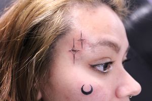 Adorn your side face with a delicate fine line star tattoo designed by the talented artist José.