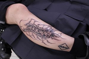 Experience the dark beauty of José's black and gray centipede pattern tattoo on your lower leg. Intricate details and bold lines make this piece a stunning addition to your body art collection.