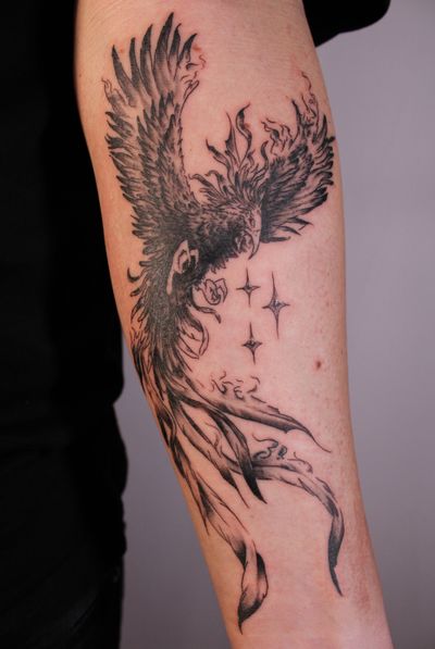 Capture the beauty of rebirth with this black and gray micro realism tattoo of a bird rising from the ashes amidst a starry night sky. By artist José.