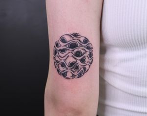 Experience the artistry of José with this black and gray upper arm tattoo featuring a mesmerizing pattern and eye motif.