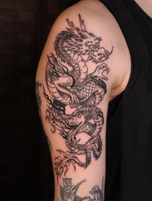 Capture the fierce power of a Japanese dragon with this intricately detailed tattoo on your upper arm. Let José bring this mythical creature to life on your skin.