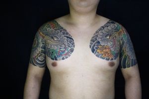 Experience the elegance of Japanese artistry with this captivating chest tattoo by the talented artist Hansol Jung. Embrace the symbolism of the snake and flower motifs intertwined in perfect harmony.