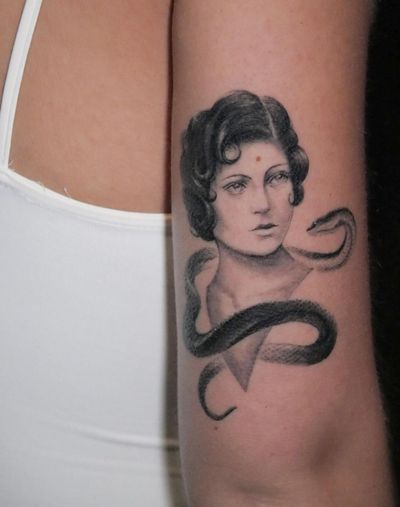 Get a striking black and gray tattoo of a snake wrapped around a woman's arm, expertly done by Alexander Rufio.