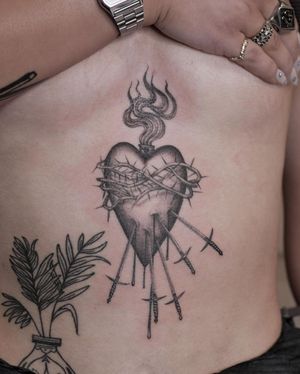 Stunning black and gray illustrative tattoo of a heart pierced by a sword, done by the talented artist Alexander Rufio.