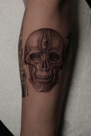 Unique forearm tattoo by Alejandro Gonzalez featuring a surrealistic design of a skull and eye in stunning black and gray ink.