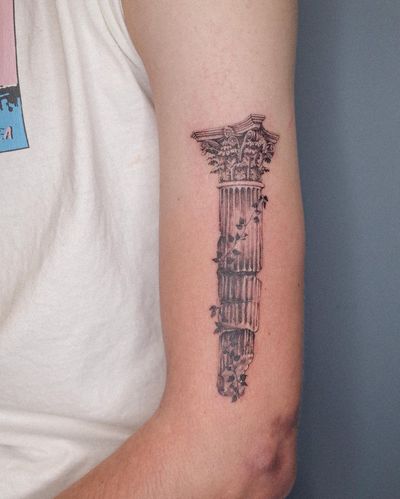 Elegant black and gray tattoo featuring a Greek column intertwined with a delicate flower, expertly done by Alexander Rufio on the upper arm.