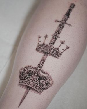 Get inked with this stunning black and gray tattoo by Alexander Rufio, featuring a detailed sword and crown design for a touch of royalty.