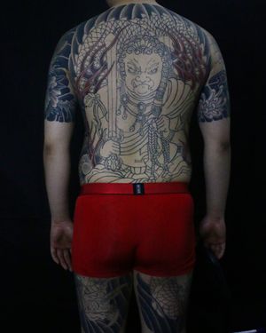 Powerful and traditional Japanese back tattoo featuring a fierce dragon and sword design, created by renowned artist Hansol Jung.