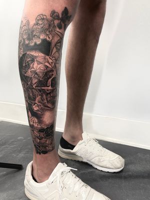 Beautiful lower leg tattoo featuring a realistic water, flower, skull, pattern, and watering can design by Gifford Kasen.