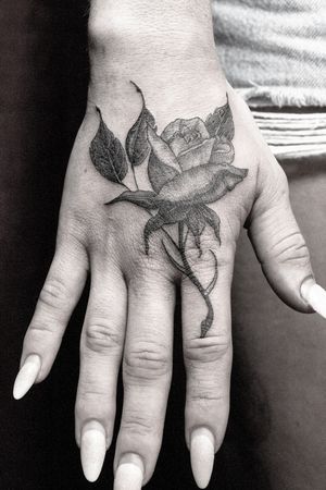 Beautiful black and gray rose tattoo on the hand by artist Gifford Kasen.