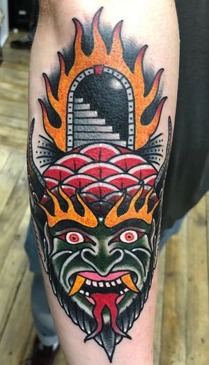 Dark and intricate traditional tattoo featuring a devil descending a staircase, done by the talented artist Carlos Zucato. Perfect for the forearm.
