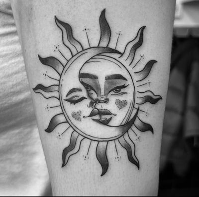 Surreal black and gray tattoo featuring a sun and moon by artist Carlos Zucato.