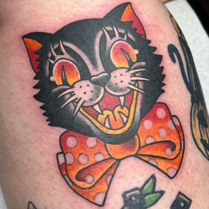Get inked with a classic cat design wearing a stylish bow tie on your arm. Tattoo by renowned artist Carlos Zucato.