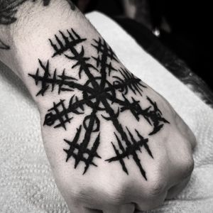 Explore the ancient Norse symbolism with this striking blackwork tattoo by Carlos Zucato, featuring a intricate pattern and a powerful Vegvisir compass design on the hand.