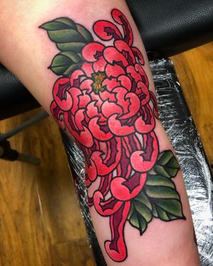 Floral beauty meets bold lines in this stunning neo-traditional chrysanthemum arm tattoo by the talented artist Carlos Zucato.