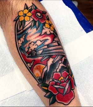 Vibrant lower leg tattoo by Carlos Zucato featuring a classic combination of flowers and airplanes in a traditional style.