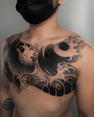 Impressive blackwork chest tattoo featuring a stunning Japanese style koi fish and waves, expertly done by FKM TATTOO.