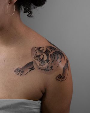 Experience the power and beauty of a black and gray Japanese tiger tattoo by FKM Tattoo on your shoulder. Impressive illustrative style.